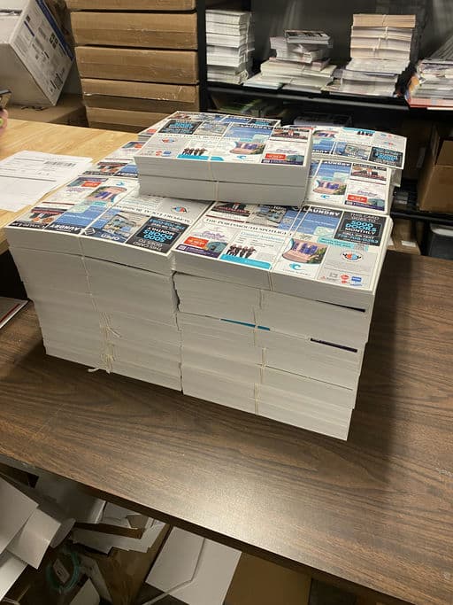 A real print run of 9x12 postcards bundled and stacked for USPS Every Door Direct Mail